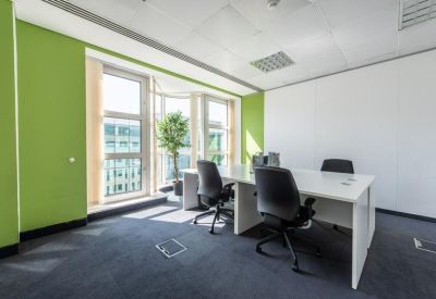 Private office with two desks and green accent wall.
