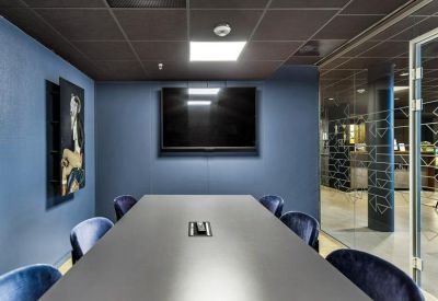 Sleek conference room with a long grey table and blue velvet chairs.