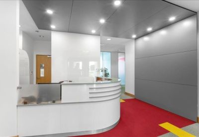 Sleek white curved reception desk with a vibrant red carpet and grey feature wall.