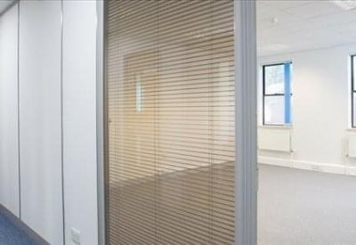 Spacious open-plan office suite with large windows and natural light.
