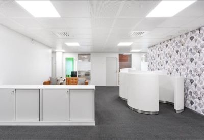 Reception lobby area featuring a modern white desk and a large decorative wall pattern.