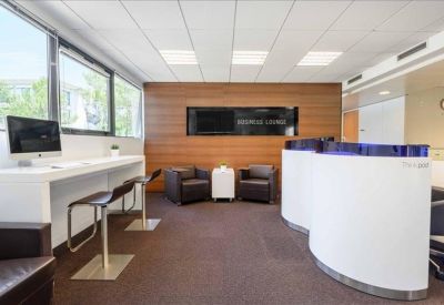 Communal lounge area with high stools, leather armchairs, and a wood-paneled feature wall.