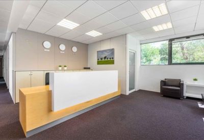 Minimalist reception area with a white front desk, wooden accents, and world clocks.