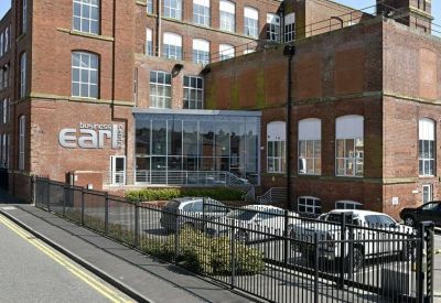 Red brick exterior view of Earl Business Centre, Dowry Street with a modern glass entrance and parking area.