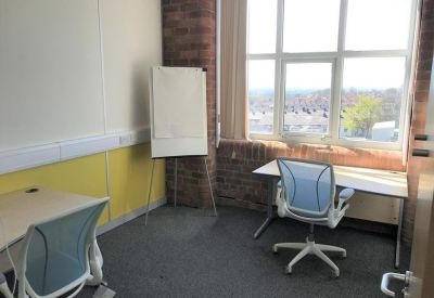 Private office featuring two desks, ergonomic chairs, and a large window overlooking the city.