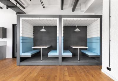 Private semi-enclosed booths with light blue upholstery for quiet work.