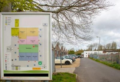 Site map signpost located at the entrance of a business park road.