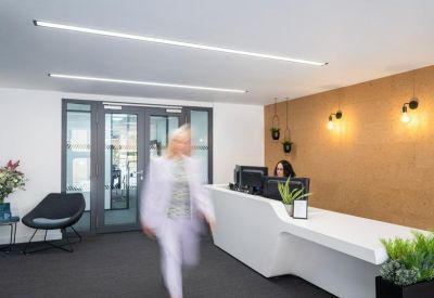 Modern reception lobby featuring a sleek white curved desk and warm feature wall.