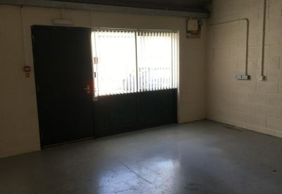 Dimly lit empty room with a large window and door.