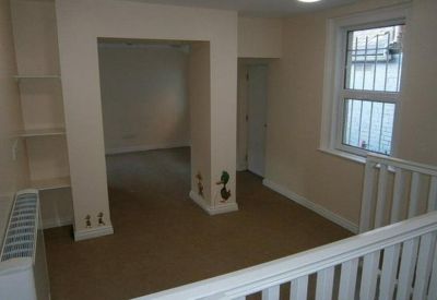 Neutral-toned office interior with an arched entryway and white bannister.