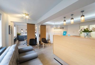 Reception area at Empress Business Centre with a light wood desk and pendant lighting.