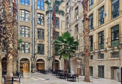 Private office featuring stone feature walls, exposed ductwork, and white desks.