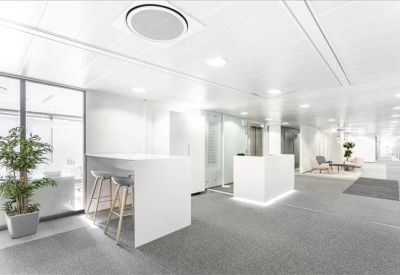 Bright reception area with a white front desk and high-top seating.