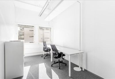 Bright private office with two workstations and window views.