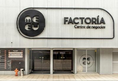 Modern entrance to the business center with black circular branding and sliding doors.
