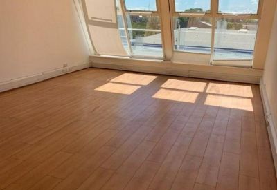 Empty office suite with light wood flooring and large windows providing natural light.