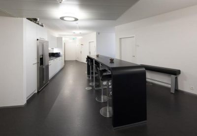Communal kitchen area with long counter and bar stools.