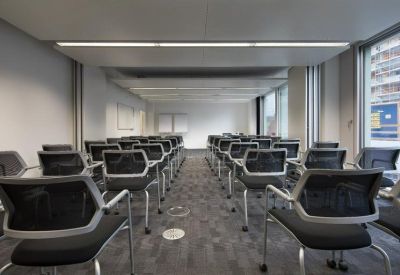 Meeting room with rows of chairs facing a whiteboard.
