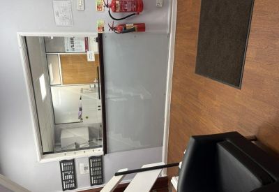 Professional reception or security desk area with fire extinguishers and wall-mounted documents.