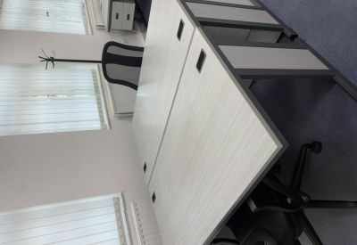 Close-up of a white office desk and mesh-back chair.