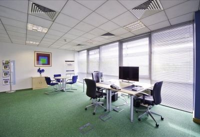 Large meeting room with white table, ergonomic chairs, and wall-mounted screen.