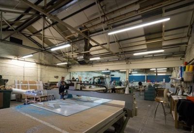 Production space featuring a large CNC cutting table and industrial equipment.
