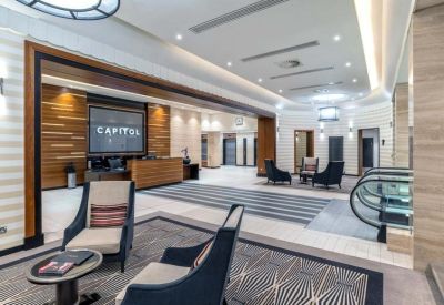Spacious modern lobby and reception area with warm wood paneling and stylish seating.