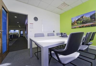 Contemporary meeting room with a white table, gray chairs, and a nature-themed wall mural.