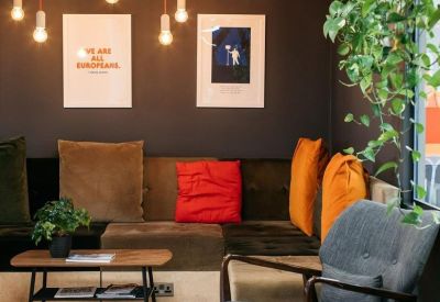 Cosy lounge area with plush seating, orange cushions, and warm pendant lighting.