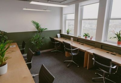 Private office suite with multiple desks, ergonomic chairs, and large windows.