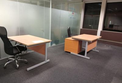Bright office space featuring frosted glass partitions and modern workstations.