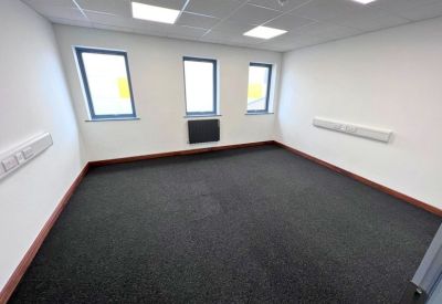 Spacious private office suite with three windows and overhead lighting.