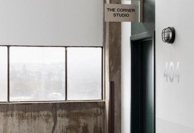 Industrial hallway featuring an entrance to The Corner Studio and concrete textures.