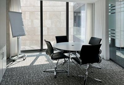 Cozy breakout area with orange armchairs, light wood shelving, and stylish pendant lights.