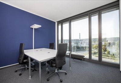 Modern four-person office with a navy blue feature wall and floor-to-ceiling windows.