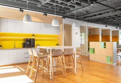 Modern breakout kitchen area with a yellow backsplash and high-top seating.