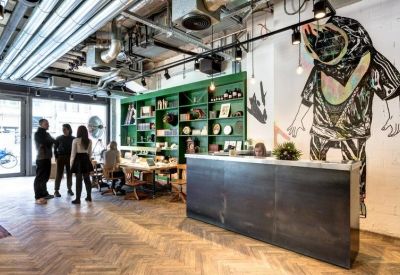 Reception desk with a minimalist metal finish and a vibrant wall illustration.
