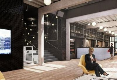 Bright reception lobby with a front desk, lounge seating, and industrial accents.