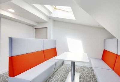 Private meeting nook with orange and grey upholstered booth seating.