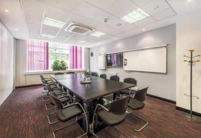 Professional boardroom with a dark wood table, black chairs, and a large whiteboard.