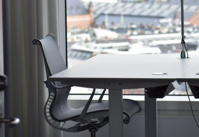 Minimalist workstation with an ergonomic chair positioned by a window overlooking the city.