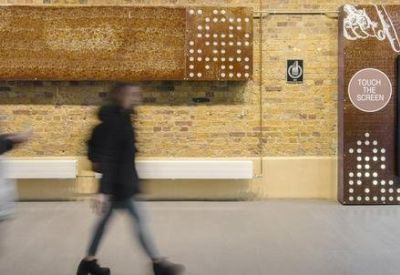 Industrial brick wall with a digital directory board and artistic signage.