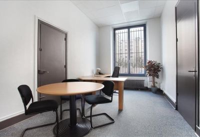 Private office suite with a round meeting table and professional desk setup.