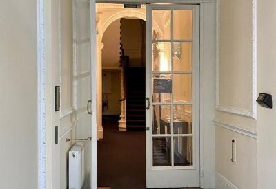 Building entrance featuring a glass-paneled inner door and a classic fanlight window.