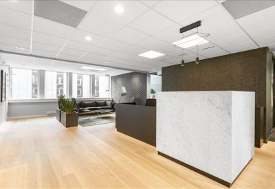 Clean white marble reception desk in an open lobby with wooden floors.