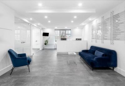 Bright reception area with a minimalist white desk and plush blue seating.