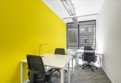Private office featuring a vibrant yellow accent wall and white desks.