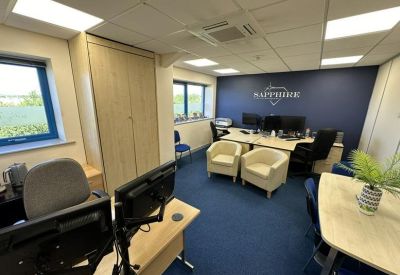 Modern office interior with blue carpeting and a branded navy blue feature wall.