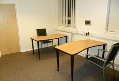 Private office suite with two wooden desks and black ergonomic chairs.