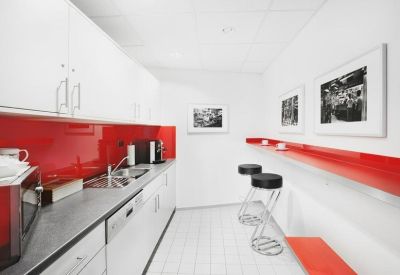 Modern breakroom kitchen with bright red backsplashes and stylish tall bar stools.